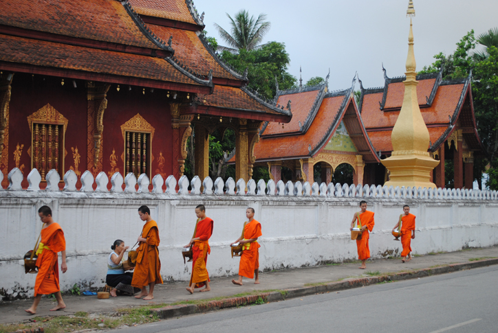 Receiving their daily alms in front of one of the many wats in Luang Prabang