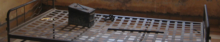 A cot in one of the larger prison cells